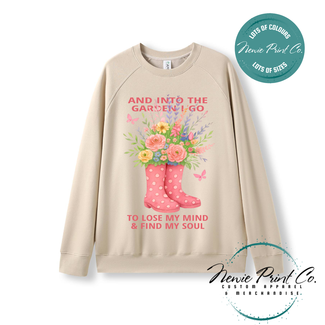 “Into the garden I go to lose my mind and find my soul” quote t-shirt featuring a pair of gumboots filled with wildflowers. Whimsical floral garden design printed on 100% cotton tee using high-quality DTF/DTG print, perfect for nature lovers and gardeners.