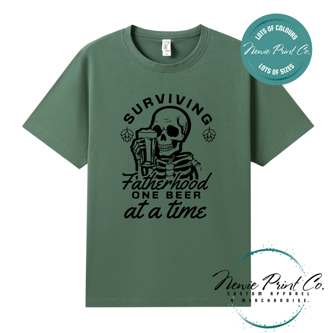 Funny t-shirt and jumper with the phrase “Surviving Fatherhood One Beer at a Time” featuring a skeleton holding a beer. Printed on soft cotton with high-quality DTF/DTG printing. Perfect humorous gift for dads, beer lovers, and Father's Day.