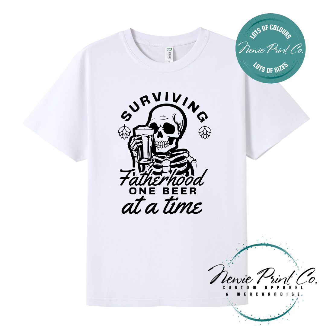 Funny t-shirt and jumper with the phrase “Surviving Fatherhood One Beer at a Time” featuring a skeleton holding a beer. Printed on soft cotton with high-quality DTF/DTG printing. Perfect humorous gift for dads, beer lovers, and Father's Day.