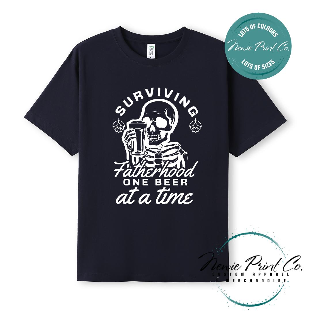 Funny t-shirt and jumper with the phrase “Surviving Fatherhood One Beer at a Time” featuring a skeleton holding a beer. Printed on soft cotton with high-quality DTF/DTG printing. Perfect humorous gift for dads, beer lovers, and Father's Day.