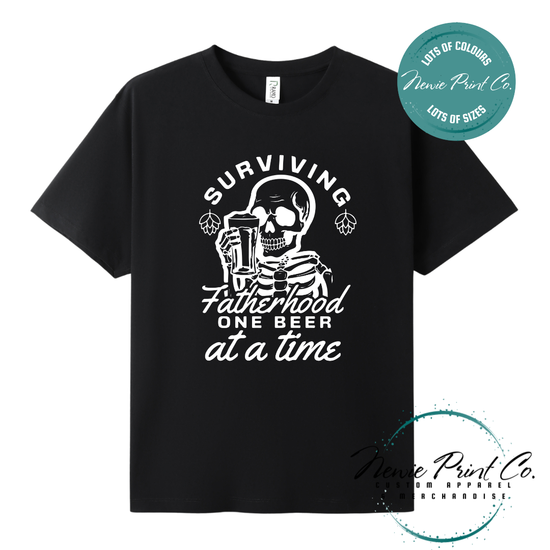 Funny t-shirt and jumper with the phrase “Surviving Fatherhood One Beer at a Time” featuring a skeleton holding a beer. Printed on soft cotton with high-quality DTF/DTG printing. Perfect humorous gift for dads, beer lovers, and Father's Day.