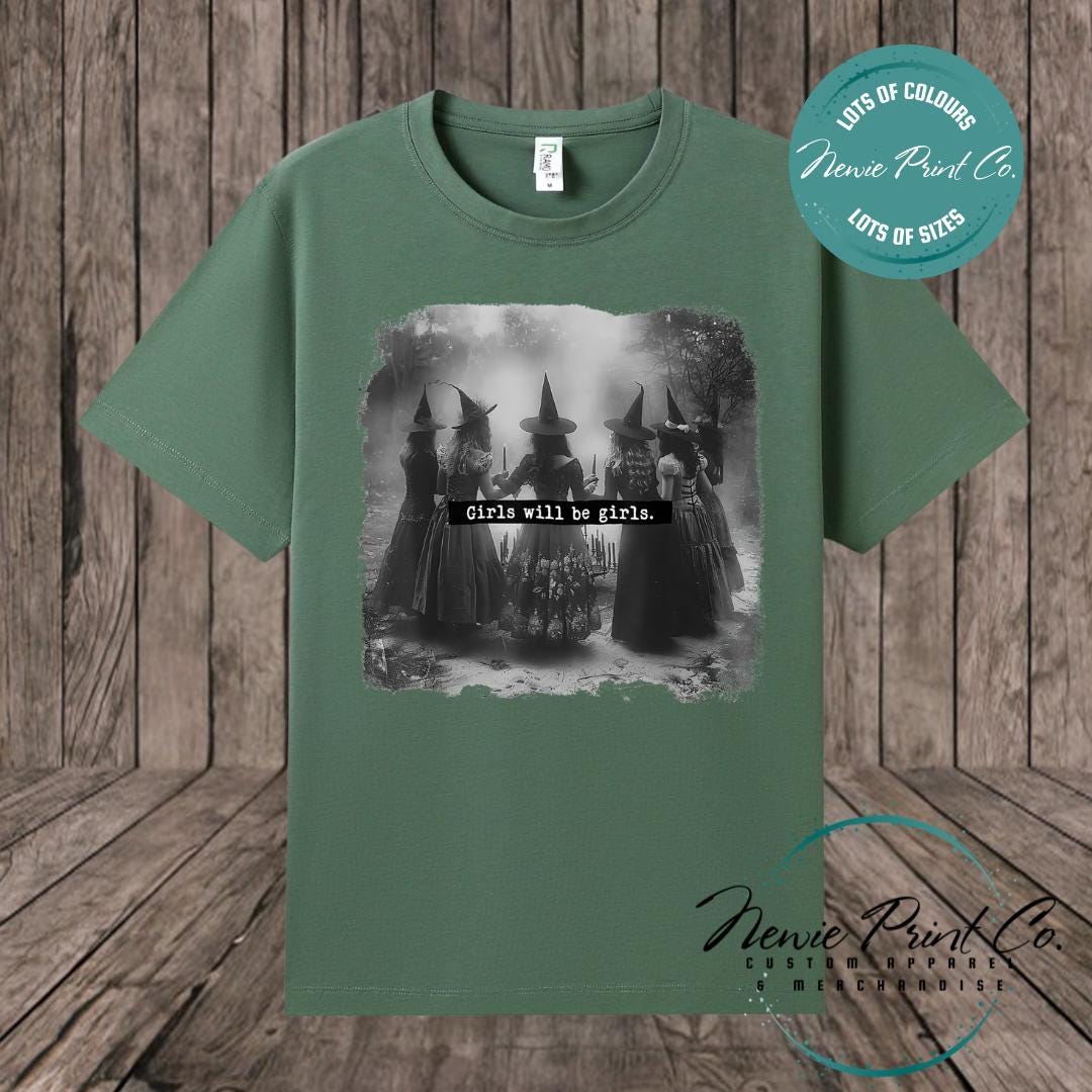 Witches in the forest design on custom t-shirt with the slogan “Girls Will Be Girls”. Feminist and empowering print on 100% cotton tee, perfect for girls and women, printed using high-quality DTF/DTG technology.