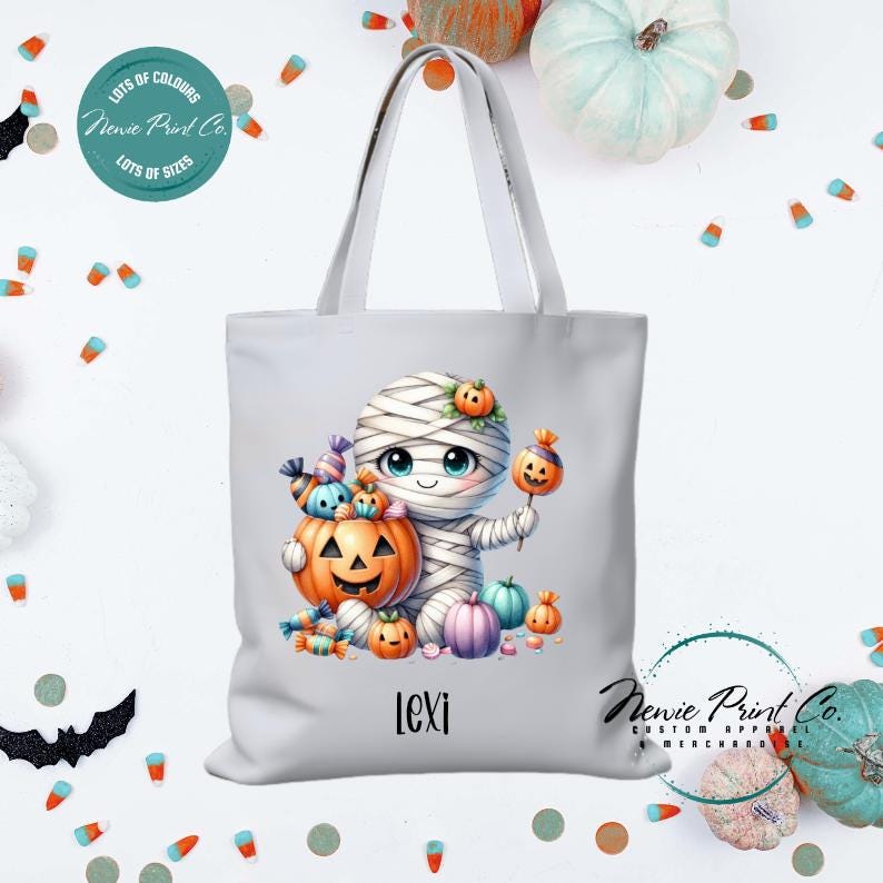 Custom Halloween tote bag with a cute mummy with candy and pumpkins, optional personalised name printed on the front, perfect for trick-or-treating or spooky season gifts printed in Australia.
