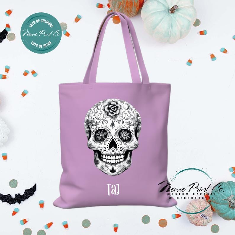 Custom Halloween tote bag with a black and white sugar skull, optional personalised name printed on the front, perfect for trick-or-treating or spooky season gifts printed in Australia.