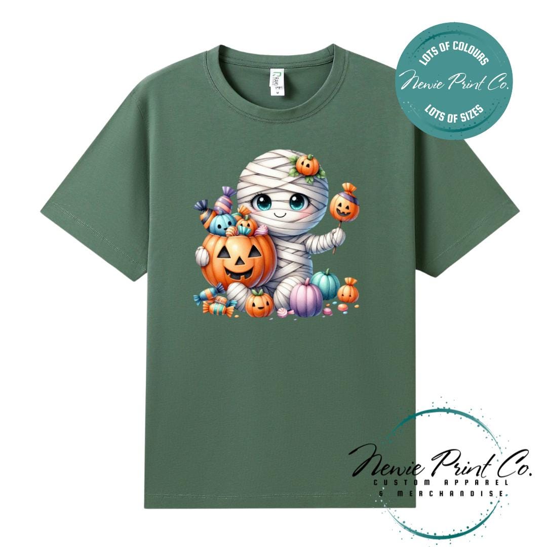 Custom Halloween t-shirts printed in Australia, featuring a cute and spooky mummy holding a pumpkin full of bright coloured candy and optional personalised names — perfect for Halloween parties, school events, or family matching outfits.