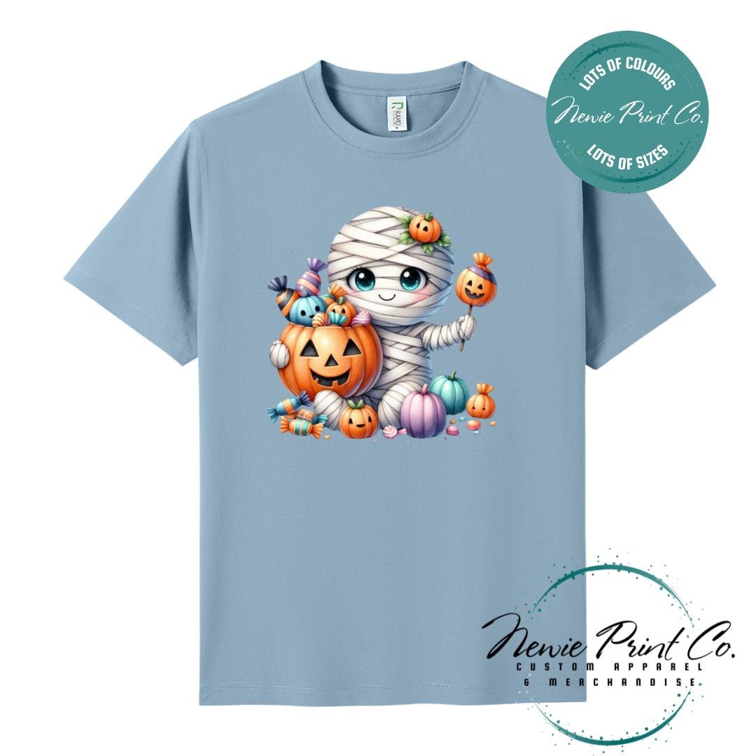 Custom Halloween t-shirts printed in Australia, featuring a cute and spooky mummy holding a pumpkin full of bright coloured candy and optional personalised names — perfect for Halloween parties, school events, or family matching outfits.