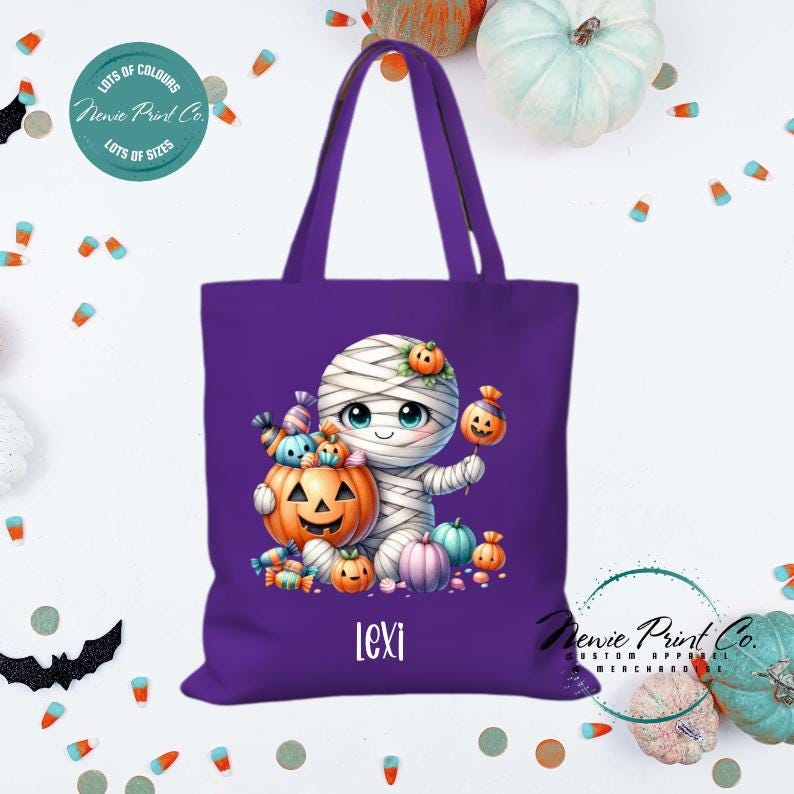 Custom Halloween tote bag with a cute mummy with candy and pumpkins, optional personalised name printed on the front, perfect for trick-or-treating or spooky season gifts printed in Australia by Newie Print Co.