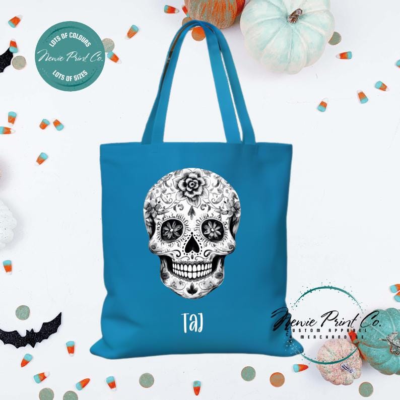 Custom Halloween tote bag with a black and white sugar skull, optional personalised name printed on the front, perfect for trick-or-treating or spooky season gifts printed in Australia.