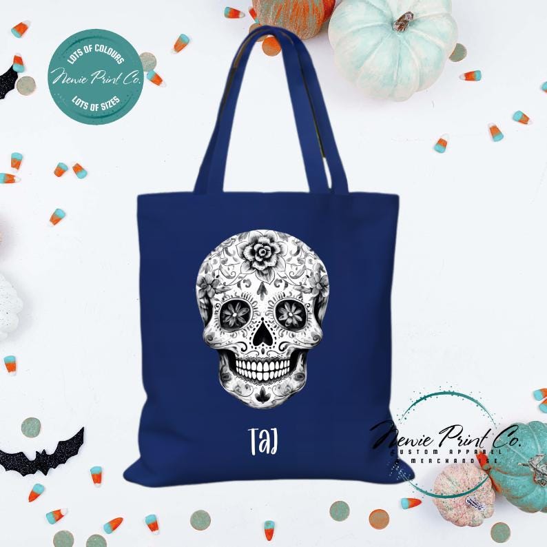 Custom Halloween tote bag with a black and white sugar skull, optional personalised name printed on the front, perfect for trick-or-treating or spooky season gifts printed in Australia by Newie Print Co.