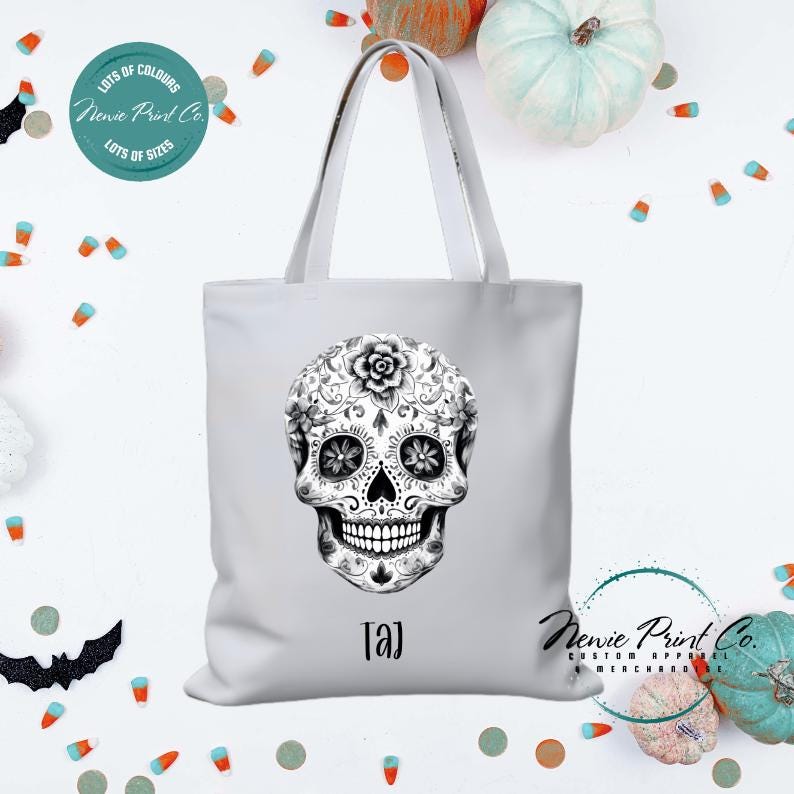 Custom Halloween tote bag with a black and white sugar skull, optional personalised name printed on the front, perfect for trick-or-treating or spooky season gifts printed in Australia.