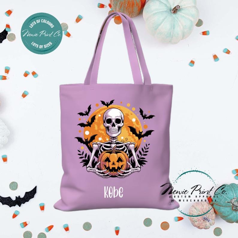 Custom Halloween tote bag with a skeleton holding a pumpkin and a big orange moon and bats behind him, optional personalised name printed on the front, perfect for trick-or-treating or spooky season gifts printed in Australia.
