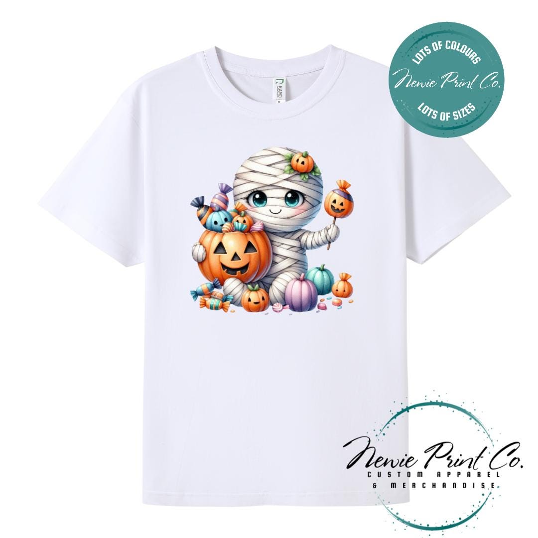 Custom Halloween t-shirts printed in Australia, featuring a cute and spooky mummy holding a pumpkin full of bright coloured candy and optional personalised names — perfect for Halloween parties, school events, or family matching outfits.