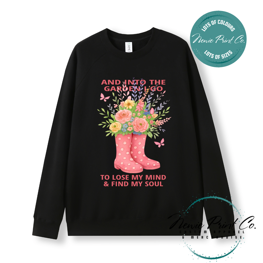 “Into the garden I go to lose my mind and find my soul” quote t-shirt featuring a pair of gumboots filled with wildflowers. Whimsical floral garden design printed on 100% cotton tee using high-quality DTF/DTG print, perfect for nature lovers and gardeners.
