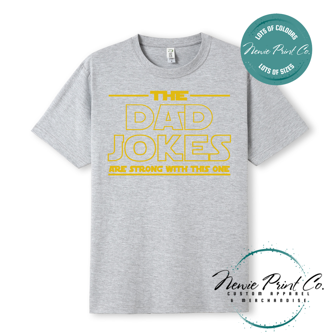 Funny t-shirt and jumper with the text “The Dad Jokes Are Strong With This One”. Humorous Star Wars-inspired quote printed on 100% cotton apparel using high-quality DTF/DTG print. Perfect gift for dads, Father’s Day, or star wars lovers.