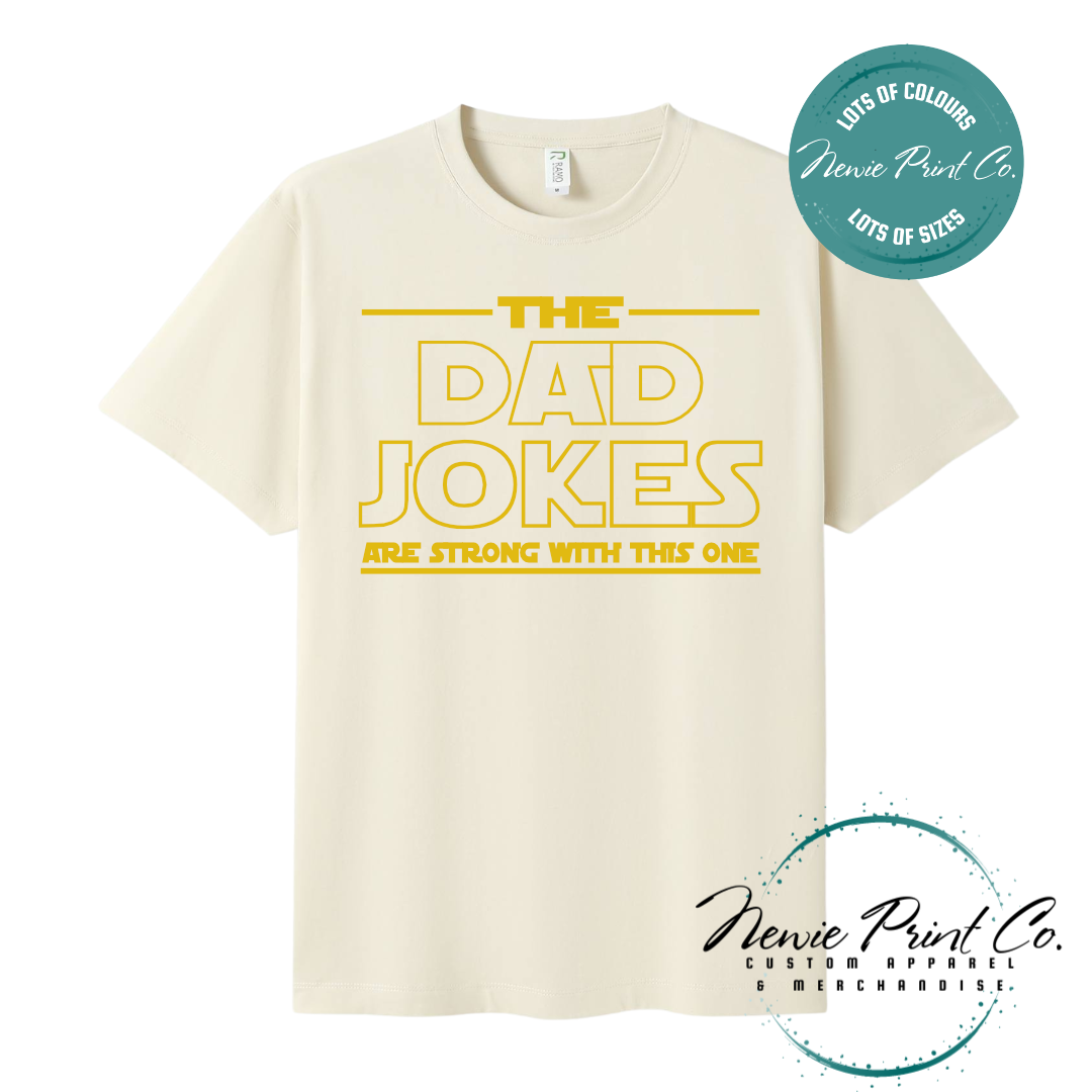 Funny t-shirt and jumper with the text “The Dad Jokes Are Strong With This One”. Humorous Star Wars-inspired quote printed on 100% cotton apparel using high-quality DTF/DTG print. Perfect gift for dads, Father’s Day, or star wars lovers.