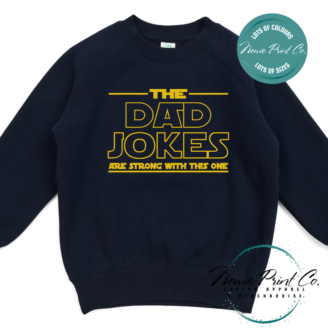 Funny t-shirt and jumper with the text “The Dad Jokes Are Strong With This One”. Humorous Star Wars-inspired quote printed on 100% cotton apparel using high-quality DTF/DTG print. Perfect gift for dads, Father’s Day, or star wars lovers.
