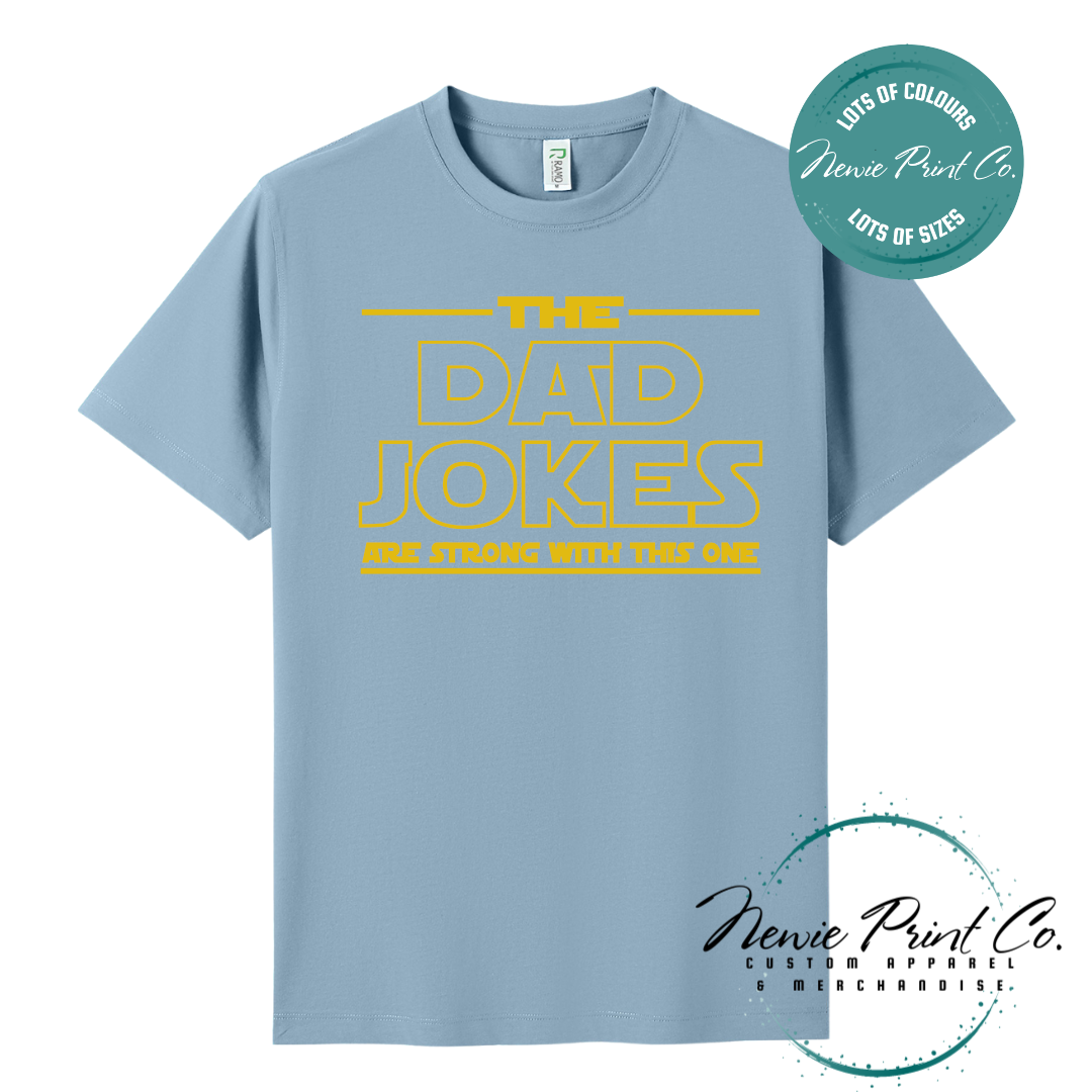 Funny t-shirt and jumper with the text “The Dad Jokes Are Strong With This One”. Humorous Star Wars-inspired quote printed on 100% cotton apparel using high-quality DTF/DTG print. Perfect gift for dads, Father’s Day, or star wars lovers.