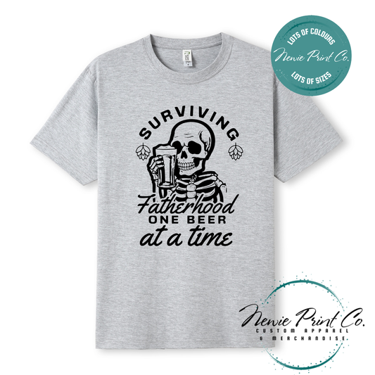 Funny t-shirt and jumper with the phrase “Surviving Fatherhood One Beer at a Time” featuring a skeleton holding a beer. Printed on soft cotton with high-quality DTF/DTG printing. Perfect humorous gift for dads, beer lovers, and Father's Day.