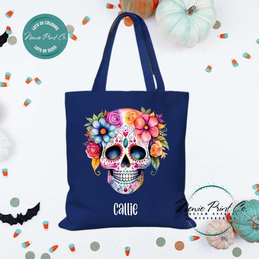 Custom Halloween tote bag with a bright floral sugar skull, optional personalised name printed on the front, perfect for trick-or-treating or spooky season gifts printed in Australia by Newie Print Co.