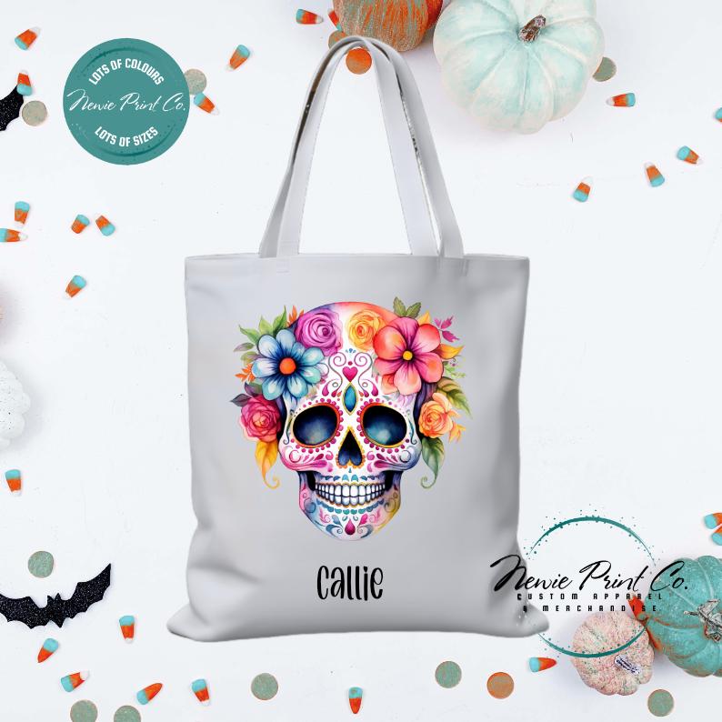 Custom Halloween tote bag with a bright floral sugar skull, optional personalised name printed on the front, perfect for trick-or-treating or spooky season gifts printed in Australia.