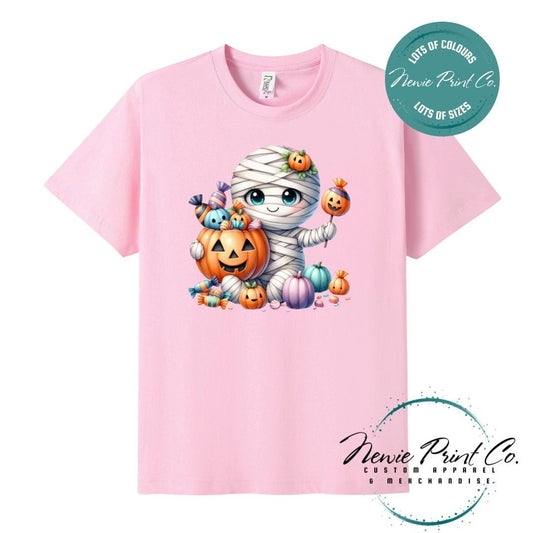 Custom Halloween t-shirts printed in Australia, featuring a cute and spooky mummy holding a pumpkin full of bright coloured candy and optional personalised names — perfect for Halloween parties, school events, or family matching outfits.