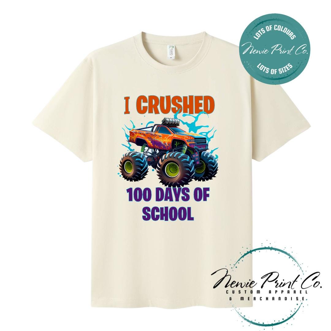 Natural 100 Days of School t-shirt featuring a bold monster truck graphic with the text “I Crushed 100 Days of School,” designed for students or teachers to celebrate the 100th day of school milestone in a fun, playful way. Available in both adult and kids sizes.