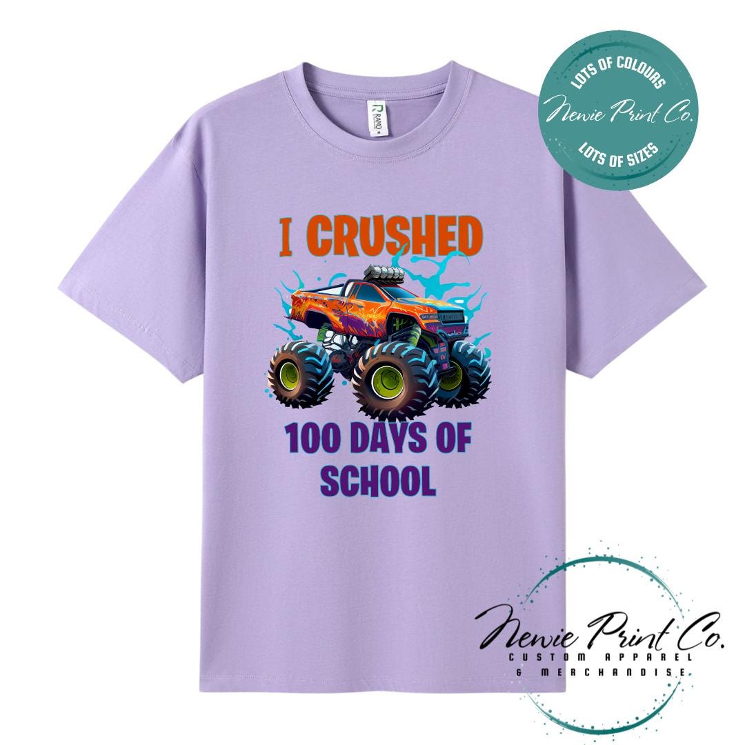 Lavender 100 Days of School t-shirt featuring a bold monster truck graphic with the text “I Crushed 100 Days of School,” designed for students or teachers to celebrate the 100th day of school milestone in a fun, playful way. Available in both adult and kids sizes.