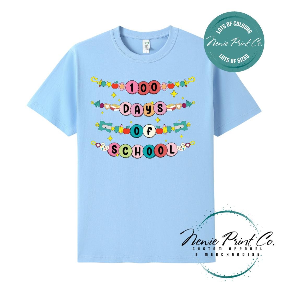 Sky Blue 100 Days of School t-shirt featuring a colourful friendship bracelet with the text “100 Days of School,” designed for students or teachers to celebrate the 100th day of school milestone in a fun, playful way. Available in both adult and kids sizes.